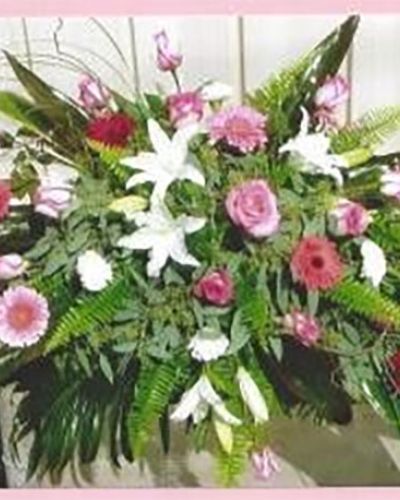 <p>A life filled with love, kindness, and quiet beauty deserves a farewell that feels just as meaningful. This full casket spray is a graceful floral tribute, designed to reflect the warmth and compassion of someone dearly missed. With its layered blend of soft and rich hues, it brings comfort to grieving hearts while honoring a legacy of love.</p>
<p>The arrangement combines red and pink roses, white lilies, carnations, and seasonal accent flowers, all set within a generous bed of lush greenery. The red blooms symbolize enduring love and strength, while the pink adds a sense of admiration and tenderness. White flowers provide a peaceful contrast, offering a message of purity and serenity. The greenery frames the entire design with natural movement, allowing the blooms to flow gently across the casket in a display of remembrance and renewal.</p>
<p>This casket cover is well-suited for funerals, celebration of life services, or graveside gatherings. Its balanced color palette brings both softness and strength to any setting, making it an appropriate choice for honoring parents, grandparents, partners, or close friends. It serves as a central tribute, inviting moments of reflection and offering beauty in the presence of sorrow.</p>
<p>Each arrangement is crafted with care, using only fresh blooms selected for their meaning and harmony. The combination of color, texture, and thoughtful design ensures that the tribute is not only visually stunning but also emotionally resonant. This casket spray becomes a final gesture of love and appreciation, expressing the deep connection shared with the one being honored.</p>
<p>Let this floral tribute bring peace and presence to the ceremony. In its quiet elegance and heartfelt composition, it stands as a reminder that love continues to bloom in memory, offering strength and solace to those left behind.</p>