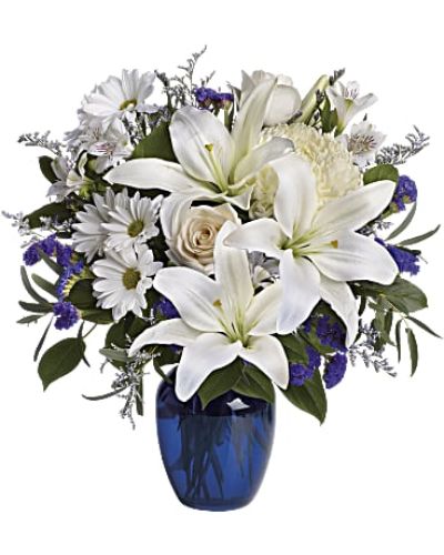 <p>Send a graceful message of serenity and sincerity with an elegant floral arrangement that blends soft whites with soothing blues. Whether offering comfort, celebrating a special occasion, or simply showing care, this bouquet delivers a calm and thoughtful presence that speaks quietly but profoundly.</p>
<p>The design features a stunning mix of blue hydrangea, creamy roses, white lilies, white alstroemeria, and a blend of yellow and white chrysanthemums. Accents of eucalyptus, limonium, and other fresh greens add texture and visual balance. All blooms are beautifully arranged in a striking blue glass vase that enhances the soft and serene color palette, creating a harmonious and inviting display.</p>
<p>This arrangement is an ideal choice for sympathy gestures, new beginnings, birthdays, or any moment when words fall short and a peaceful expression is needed. The blend of cool tones and delicate florals creates a soothing atmosphere that brings beauty and comfort to homes, offices, or special events.</p>
<p>Each bouquet is handcrafted with care by experienced floral designers, ensuring every bloom is fresh and perfectly placed. Prepared locally and delivered with attention and respect, the arrangement arrives fragrant and vibrant, ready to brighten the recipient’s day. Personalized messages can be added to deepen the sentiment and create a more memorable gift.</p>
<p>By sending this arrangement, you offer more than flowers—you share a timeless symbol of compassion, gratitude, and celebration. Its calming colors and elegant composition provide a lasting reminder of kindness and thoughtful connection during life’s meaningful moments.</p>
