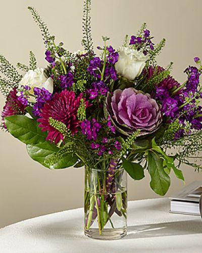 <p>When words aren’t enough, let a bold and beautiful bouquet express what’s in your heart. This luxurious arrangement captures the passion and depth of true emotion through rich color, dramatic contrast, and imaginative texture. It’s a romantic statement designed to stir the senses and leave a lasting impression.</p>
<p>The bouquet features a striking mix of royal purple Cremon mums, deep pink Sweet William dianthus, soft spray stock, and creamy white roses. Artistic accents like decorative kale add unexpected texture and a fresh-from-the-garden aesthetic. Together, these blooms create a layered composition that’s moody, expressive, and full of personality.</p>
<p>Hand-arranged in a classic clear glass vase, the design balances elegance with creativity. The varied heights and textures allow each bloom to shine while drawing the eye from every angle. Whether placed on a dining table, entryway, or desk, this bouquet brings a sense of romance and drama to any setting.</p>
<p>Perfect for anniversaries, romantic gestures, congratulations, or heartfelt surprises, this arrangement conveys affection with sophistication and flair. Its blend of soft and bold tones symbolizes a love that’s both tender and powerful—complex, captivating, and unforgettable.</p>
<p>Each bouquet is crafted by hand using fresh, premium blooms. While flower varieties may vary slightly based on seasonal availability, the rich color palette and expressive style will remain beautifully intact. Give a gift that reflects your deepest feelings with a floral design that’s as unrestrained and romantic as love itself.</p>
