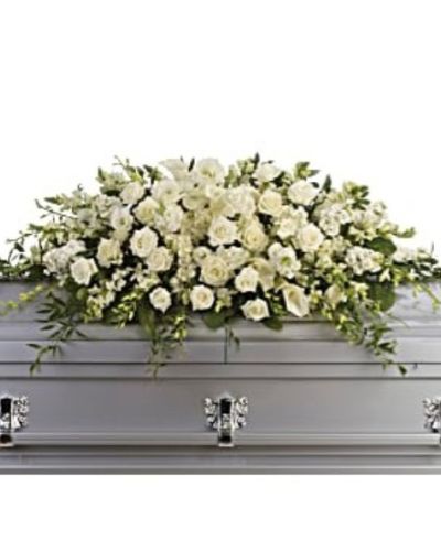 <p>Honor the life of a loved one with an all-white casket spray that radiates tranquility, reverence, and timeless beauty. Designed for a full couch or closed casket service, this large-scale arrangement offers a graceful expression of remembrance through some of nature’s most elegant blooms.</p>
<p>This lush tribute features a carefully chosen combination of white roses, dendrobium orchids, large calla lilies, and full white hydrangea. Each flower symbolizes purity and meaning—roses for love, orchids for respect, calla lilies for renewal, and hydrangea for heartfelt emotion. The soft textures and clean color palette create a peaceful presence, bringing calm to a solemn moment.</p>
<p>This arrangement serves as a fitting farewell for a life marked by grace, kindness, and quiet strength. Its gentle beauty provides comfort to family and friends while acting as a meaningful tribute to someone whose legacy lives on in love and memory.</p>
<p>Each piece is handcrafted with care and attention to detail, made fresh to order to reflect dignity and compassion. Personal messages can be added at checkout to share thoughts and support, offering a heartfelt way to commemorate life’s tender moments.</p>
<p>This tribute offers a serene and powerful way to say farewell with love and grace, making it a respectful and thoughtful expression of remembrance.</p>