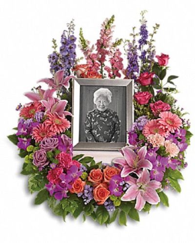 <p>Honor a cherished life with a wreath that beautifully expresses devotion and lasting memories. This softly elegant tribute is designed to convey affection, respect, and heartfelt sympathy during a time of loss.</p>
<p>The arrangement features a rich mix of blooms including purple orchids, asters, orange, dark pink, and lavender roses, as well as pink and peach carnations. Accents of lavender larkspur, green chrysanthemums, oriental lilies, gerberas, snapdragons, and other seasonal flowers create a lush, vibrant display.</p>
<p>Ideal for funerals, memorial services, or as a thoughtful sympathy gift, this wreath serves as a loving reminder of the bond shared and memories treasured. Please note this arrangement does not include a picture frame and is intended solely as a floral tribute.</p>
<p>Each wreath is handcrafted by skilled florists who ensure it arrives fresh and beautifully arranged. Same-day delivery is available to provide timely and respectful service.</p>
<p>Add a personal message to accompany your gift. This wreath sends a lasting symbol of love, remembrance, and sincere compassion.</p>
