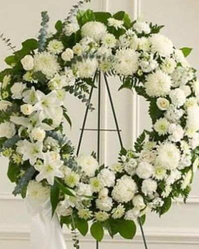 <p>Honor a life of love, dignity, and grace with the timeless beauty of the Serene Sympathies Standing Wreath in white. This elegant tribute offers a heartfelt expression of sympathy, serving as a gentle and respectful presence during times of mourning.</p>
<p>Handcrafted by expert florists, this standing wreath features a serene blend of fresh white roses, football mums, and carnations. Accented with spiral eucalyptus, salal, and other lush greens, the circular design symbolizes eternal love and remembrance. Displayed on a standing easel, it offers a graceful focal point at any funeral or memorial service.</p>
<p>Appropriate for delivery by family, friends, or business associates, this wreath conveys compassion and support with classic sophistication. The all-white color palette reflects purity, peace, and reverence—making it a fitting tribute for honoring someone deeply cherished.</p>
<p>Each Serene Sympathies Standing Wreath in white is carefully arranged with attention to detail. Reliable same-day delivery is available to funeral homes and memorial venues throughout the local area, ensuring your tribute arrives fresh and beautifully presented.</p>
<p>Add a personal message at checkout to share your condolences and support. Let this graceful wreath help you express what words often cannot—with quiet strength and lasting beauty.</p>