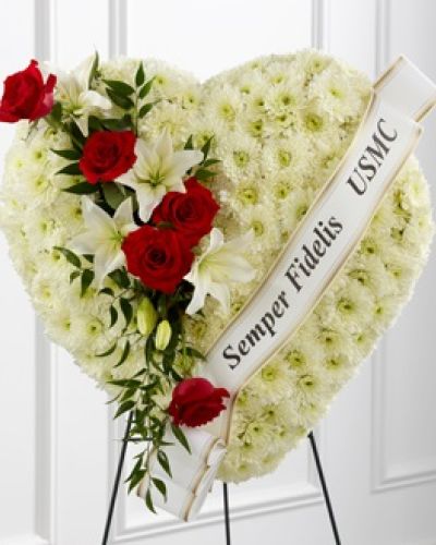 <p>Express profound sympathy and honor a cherished life with this elegant, standing heart-shaped floral arrangement. Designed to convey heartfelt condolences with grace and reverence, it embodies eternal love, remembrance, and deep appreciation. At times when words seem inadequate, this sophisticated tribute gracefully communicates compassion and sincere respect, offering comfort during periods of sorrow and reflection.</p>
<p>Expertly crafted in the symbolic form of an open heart, this arrangement begins with a gentle base of lush white cushion pompons. Known for their soft, tranquil beauty, these blossoms symbolize innocence, purity, and the enduring presence of loving memories. Thoughtfully blended throughout the design are vibrant red roses and pristine white lilies, both selected for their traditional significance in expressing love, admiration, and the timeless beauty of the spirit.</p>
<p>Each bloom within this arrangement is thoughtfully positioned by experienced florists to ensure harmony, depth, and a visually striking presence. The arrangement subtly captures feelings of reverence and admiration, ideal for memorializing individuals whose lives exemplified bravery, sacrifice, or exceptional kindness. Its dignified elegance makes it particularly fitting for honoring veterans, first responders, community leaders, or any loved one whose legacy deserves special recognition.</p>
<p>Securely displayed on a sturdy wire easel, the arrangement provides both beauty and stability for ceremonies, funerals, memorial services, or other commemorative events. The craftsmanship of each tribute is meticulous, ensuring the freshness, integrity, and emotional resonance of every bloom. This attention to detail ensures that the floral heart serves not only as a heartfelt expression of sympathy but also as a dignified centerpiece reflecting profound respect and lasting admiration.</p>
<p>Choosing this heartfelt floral tribute conveys thoughtful support and enduring affection during difficult times. It stands not merely as a gesture of sympathy but as an eloquent representation of love, honor, and eternal remembrance, allowing its gentle presence to comfort grieving families and communities long after formal ceremonies conclude.</p>
