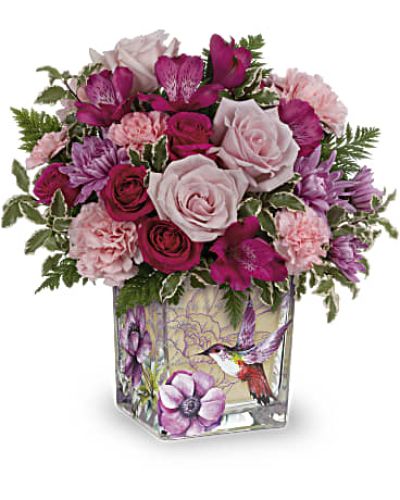 <p>Delight someone special with a bouquet that feels as delicate and joyful as a hummingbird in flight. This charming arrangement captures the wonder of a blooming garden, offering a thoughtful expression of love, appreciation, or celebration. With its airy beauty and rich color palette, it brings a breath of spring into any room.</p>
<p>The bouquet features hot pink spray roses for vibrance, paired with rich pink alstroemeria and soft pink carnations that lend warmth and softness. Lavender cushion chrysanthemums provide a calm balance, while miniature pink blooms add fine detail and texture. Accents of greenery, including leatherleaf fern and pitta negra, give the arrangement a fresh and graceful finish.</p>
<p>Designed in a vintage-style glass cube vase, the compact presentation fits beautifully on desks, tables, or windowsills. Its timeless design and soft elegance make it ideal for smaller spaces that deserve a pop of natural beauty. The vase complements the flowers without overpowering them, letting the soft colors and textures take center stage.</p>
<p>This bouquet is a lovely choice for Mother’s Day, birthdays, or thoughtful “just because” gifts. Its bright yet gentle tones reflect tenderness and joy, making it perfect for honoring a mother, surprising a friend, or expressing heartfelt emotion in a subtle and beautiful way.</p>
<p>Handcrafted with care by a professional florist, each bouquet is made using fresh, seasonal blooms. Flower types and foliage may vary slightly based on availability, but the overall look remains soft, joyful, and full of life. Share a floral moment that feels light, meaningful, and as graceful as nature itself.</p>