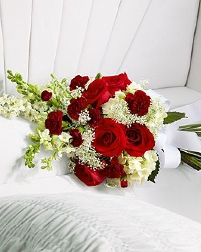<p>Honor your loved one with a final gesture of beauty and elegance through this delicate casket adornment. Designed to rest gently on the casket, it adds a refined accent to the service while expressing heartfelt love and remembrance.</p>
<p>The arrangement features vivid red roses and miniature red carnations, offering a striking contrast to soft white hydrangea, larkspur, snapdragons, and Queen Anne’s Lace. This blend of bold and gentle tones reflects the complexity of love and loss—passion, admiration, and peace all expressed in one beautiful composition. A white grosgrain ribbon ties the bouquet together, symbolizing unity, purity, and the lasting bond with the one who has passed.</p>
<p>Ideal for adding a personal, meaningful touch to a larger floral display or for those who prefer a more subtle tribute, this adornment complements full casket sprays and standing arrangements while standing gracefully on its own as a gentle farewell.</p>
<p>Each arrangement is handcrafted with care, attention to detail, and sensitivity to the occasion. Delivery is coordinated directly with funeral homes and service venues to ensure respectful presentation. Same-day delivery is available for timely and seamless service.</p>
<p>Add a personal message during checkout to accompany your floral tribute with dignity and compassion. This casket adornment helps you say goodbye with beauty, grace, and heartfelt care.</p>
