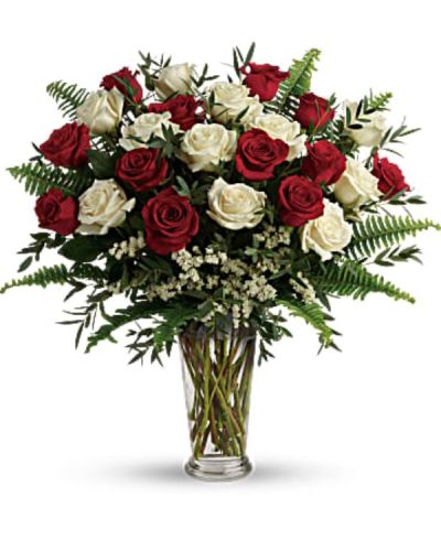 <p>Celebrate a love that runs deep with this exquisite bouquet designed to speak volumes without saying a word. Crafted to leave a lasting impression, this arrangement brings together the rich romance of red roses and the pure elegance of white roses for a truly heartfelt gift. Whether marking a milestone, renewing a promise, or simply showing how much you care, this bouquet is a classic floral expression of enduring affection.</p>
<p>This deluxe design features eighteen premium roses—half red, half white—expertly arranged among airy white sinuata statice and textured parvifolia eucalyptus. Accents of sword fern add a graceful touch, creating a full and balanced composition that feels both timeless and fresh. The arrangement is presented in a stately clear Romanesque vase, offering a refined silhouette that beautifully elevates the lush blooms inside.</p>
<p>Perfect for anniversaries, Valentine’s Day, or spontaneous romantic surprises, this bouquet makes it easy to show devotion with style and sincerity. The red roses symbolize deep passion and lasting love, while the white roses reflect purity, admiration, and new beginnings. Together, they create a harmonious blend that tells a complete love story—one filled with warmth, balance, and meaning.</p>
<p>Each bouquet is hand-designed with care and artistry to ensure freshness and beauty. Same-day delivery is available to ensure your gift arrives perfectly presented and ready to express your feelings. Every arrangement reflects personal attention and expert craftsmanship.</p>
<p>Include a personal note at checkout to make your gesture even more special. Whether a few heartfelt words or a poetic tribute, your message will arrive alongside a bouquet that captures your feelings perfectly. Let your love bloom in the most beautiful way with a gift that speaks from the heart.</p>