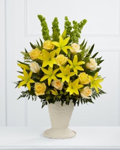<p>Celebrate the brightness and warmth a loved one brought into your life with this uplifting arrangement of yellow and cream blooms. It offers a message of remembrance filled with hope, light, and admiration.</p>
<p>Brilliant yellow Asiatic lilies and golden roses take center stage, radiating energy and positivity in honor of a life that touched many. Cream roses soften the palette with elegance and grace, while solidago and Bells of Ireland add vibrant texture and dimension. Teepee palm fronds and assorted lush greenery bring movement and structure, creating a striking tribute that evokes serenity and strength.</p>
<p>Presented in a large papier-mâché urn, this arrangement provides a dramatic and thoughtful presence at memorial services, funerals, or celebrations of life. The urn’s natural style and generous shape reflect both beauty and dignity, making it an ideal focal point near the casket, entryway, or altar.</p>
<p>Designed and hand-arranged with care by experienced florists, this sympathy arrangement is available for same-day delivery in the local area. Every bloom is chosen to honor a life with sincerity and beauty, ensuring your message is thoughtfully expressed.</p>
<p>This arrangement allows you to celebrate a life with warmth, grace, and remembrance. Whether attending the service or sending from afar, it serves as a lasting expression of love and support. Add a heartfelt message during checkout to accompany your flowers with comfort and care.</p>