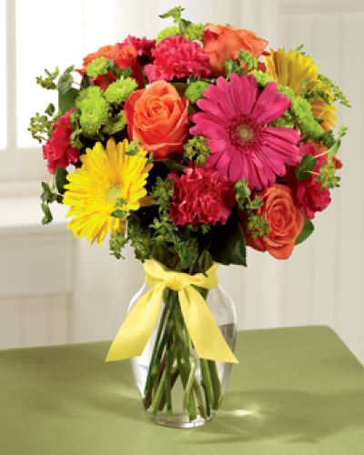 <p>Celebrate life’s happy moments with this bouquet bursting with optimism, energy, and color. Designed to inspire smiles and lift spirits, it’s perfect for sharing joy with someone special.</p>
<p>A lively mix of orange roses, hot pink and yellow gerbera daisies, hot pink carnations, green button poms, and bupleurum come together in a sunny, uplifting display. Accented with lush greenery and arranged in a clear glass vase tied with a soft yellow satin ribbon, the look is fresh, playful, and heartwarming.</p>
<p>This bouquet is a wonderful choice for birthdays, congratulations, get-well wishes, or simply brightening someone’s week. Its bright colors and happy energy bring sunshine wherever it goes, reminding that small gestures create unforgettable moments.</p>
<p>Each bouquet is carefully handcrafted by experienced florists and available for same-day delivery locally. Fresh, hand-selected blooms are arranged with personal care, never mass-produced.</p>
<p>Add a heartfelt message during checkout to personalize your gift. With this arrangement, you’re sending happiness beautifully wrapped in color. Order today to help someone look forward to brighter days.</p>