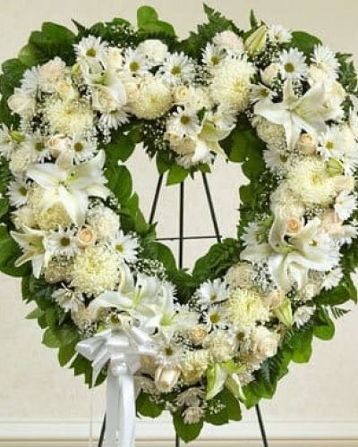 <p>A tender expression of everlasting love, the Forever Cherished Floral Heart Tribute in white is a timeless way to honor a life well lived. This stunning heart-shaped arrangement speaks volumes when words alone cannot, symbolizing deep affection, reverence, and remembrance in every petal.</p>
<p>Carefully handcrafted by expert florists, this elegant standing spray features an all-white palette that radiates peace and purity. Fresh white roses offer timeless beauty, while lilies and carnations add soft, graceful texture. Baby’s breath creates a delicate halo effect around the heart, and lush greenery—including salal and leather leaf—adds fullness and natural contrast. A satin ribbon ties the design together, lending a final note of grace to this solemn tribute.</p>
<p>Designed to be displayed on an easel at funeral homes, churches, or memorial services, this floral heart is traditionally sent by close friends or family members. Its classic shape and calming color scheme make it an ideal choice for conveying unconditional love, deep sympathy, or heartfelt remembrance. Whether used to celebrate a life filled with kindness or to bring comfort to grieving hearts, this tribute serves as a poignant reminder that love endures beyond loss.</p>
<p>Each arrangement is made with care and hand-delivered by trusted local florists known for quality, compassion, and attention to detail. The gift arrives fresh and beautifully presented, whether to a funeral service, place of worship, or the family’s home. Local delivery allows you to express support in a personal, meaningful way—even when you cannot be there in person.</p>
<p>Let the Forever Cherished Floral Heart Tribute in white serve as a gentle but powerful symbol of connection, remembrance, and peace. It’s more than flowers—it’s a message of love that will not be forgotten.</p>