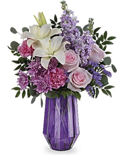 <p>Wish her a day filled with wonder and whimsy with a bouquet as breathtaking as she is. The Lavender Whimsy Bouquet blends soft roses and elegant lilies in a stunning geometric glass vase, offering a gift that feels both magical and heartfelt.</p>
<p>This lovely arrangement features light pink roses, white Asiatic lilies, and pink carnations, paired with fragrant lavender stock and lavender cushion spray chrysanthemums. Accents of lavender sinuata statice, silver dollar eucalyptus, and huckleberry bring added texture and lush greenery, completing the design with graceful charm.</p>
<p>Perfect for Mother’s Day or honoring any special woman in your life, this bouquet offers a beautiful way to express love and appreciation. Its soft hues and elegant styling create a lasting impression filled with warmth and sophistication.</p>
<p>Each arrangement is handcrafted by skilled local florists using the freshest seasonal blooms. Some flowers may arrive in bud form for longer-lasting beauty. Local delivery is available to ensure your thoughtful gesture arrives fresh and full of care.</p>
<p>Send the Lavender Whimsy Bouquet to brighten her day with elegance, love, and floral grace.</p>