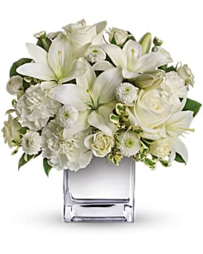 <p>Simple, graceful, and full of meaning, this striking all-white bouquet brings calm, beauty, and a quiet sense of celebration to any occasion. Though compact in size, its elegant design leaves a lasting impression.</p>
<p>The arrangement features a stunning mix of white roses, spray roses, Asiatic lilies, carnations, and button spray chrysanthemums. Accented with fresh greenery and presented in a mirrored silver cube vase, the bouquet offers a modern, luminous touch that enhances its clean and peaceful aesthetic.</p>
<p>This bouquet is an ideal gift for holiday gatherings, sympathy gestures, anniversaries, or as a sophisticated expression of love and thoughtfulness. Its soft color palette and gentle floral selection make it perfect for both festive and reflective moments.</p>
<p>Each bouquet is carefully handcrafted with attention to detail and made fresh to order. Same-day delivery is available locally, ensuring your gift arrives fresh and beautifully arranged with care and precision.</p>
<p>You can add a thoughtful message during checkout to personalize your delivery. This bouquet sends more than flowers—it sends a gesture of elegance, hope, and heartfelt connection.</p>
