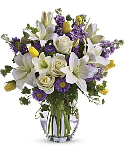 <p>Welcome the gentle awakening of spring with a bouquet that feels like a breath of fresh air. This graceful arrangement captures the season’s beauty with soft pastels, delicate textures, and an uplifting energy that brightens both spaces and spirits. It’s an elegant choice for celebrating life’s simple joys, sending warm wishes, or marking a meaningful occasion.</p>
<p>A soft blend of white Asiatic lilies, creamy roses, golden tulips, and shades of lavender stock and matsumoto asters gives the bouquet its timeless charm. Each bloom offers a unique shape and hue, creating a harmonious dance of light and color. Accents of bupleurum, ivy, and seeded eucalyptus add natural depth, while a tall clear glass vase enhances the airy, flowing silhouette of the arrangement.</p>
<p>This design evokes the feel of a walk through a blooming garden—quiet, refreshing, and full of promise. Its calming palette and organic style make it a beautiful centerpiece or an unforgettable gift. Whether placed on a dining table, entryway, or windowsill, it brings the lightness of spring indoors.</p>
<p>Thoughtfully arranged and hand-delivered by a professional florist, this bouquet is crafted using the freshest flowers available. Subtle variations in bloom type or size may occur due to seasonal shifts, but the spirit of the design remains consistently fresh and uplifting. Some blossoms may arrive in bud form, offering the recipient the joy of watching them gently unfold.</p>
<p>Celebrate new beginnings, heartfelt connections, and everyday beauty with a floral gift that perfectly captures the essence of springtime—elegant, joyful, and full of life.</p>