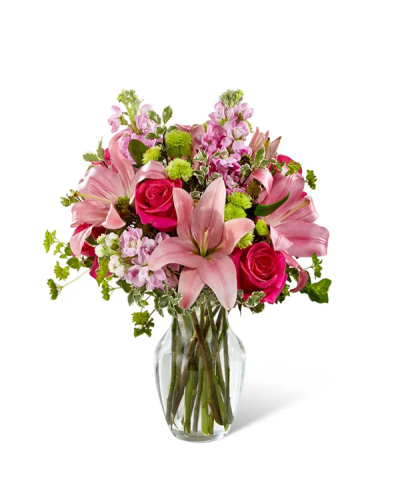 <p>When life calls for a vibrant and meaningful gesture, this bold bouquet rises to the occasion with undeniable charm. Bursting with energy and personality, it’s a joyful way to show someone they’re appreciated, celebrated, or simply on your mind. Whether for a birthday, anniversary, or spontaneous moment of kindness, this arrangement brings beauty and connection in every bloom.</p>
<p>The bouquet features a striking mix of hot pink roses that add vibrant flair, softened by pale pink Asiatic lilies for an elegant touch. Lavender stock offers a delicate contrast, while green button poms and sprigs of bupleurum introduce texture and freshness reminiscent of a garden in full bloom. Lush greenery completes the design, adding fullness and drawing out the natural vibrancy of each flower.</p>
<p>Perfect for those who love color with a contemporary twist, this bouquet stands out with confidence and style. It arrives in a classic clear glass vase that keeps the focus on the flowers and works beautifully in any setting, from a cozy breakfast nook to a modern workspace. Whether shared with a friend, partner, or loved one, this design creates a lasting impression of warmth and thoughtfulness.</p>
<p>This bouquet makes an ideal gift for a variety of occasions. From celebrating milestones and achievements to brightening someone’s day just because, its cheerful tones and bold presentation deliver more than beauty—they convey intention and heart. Each arrangement is handcrafted with attention to color, texture, and composition to ensure maximum impact and enjoyment.</p>
<p>Let this bouquet speak volumes through its vivid hues and lively design. It’s more than a floral arrangement—it’s a joyful message delivered in petal form, offering happiness, encouragement, and a lasting reminder of how much someone matters.</p>