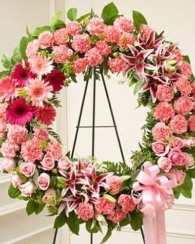 <p>Offer a tender tribute filled with warmth, compassion, and remembrance. The Serene Sympathies Standing Wreath in pink is a graceful symbol of love and support, designed to bring comfort and beauty during a time of sorrow.</p>
<p>This elegant standing wreath features a soft blend of pink roses, stargazer lilies, carnations, and seasonal blooms. Accented with salal and seeded eucalyptus, and arranged in a traditional circular form, the design symbolizes eternal love and unbroken remembrance. Mounted on a standing easel, it creates a serene focal point at any funeral or memorial service.</p>
<p>Appropriate for family members, close friends, or business associates, this wreath expresses sympathy in a heartfelt and dignified way. The pink palette represents admiration, gratitude, and gentle affection, offering a peaceful and uplifting presence for those who are grieving.</p>
<p>Each Serene Sympathies Standing Wreath in pink is handcrafted by expert florists with care and attention to detail. Same-day delivery is available to funeral homes and service venues throughout the local area, ensuring each tribute arrives fresh and respectfully presented.</p>
<p>Include a personal sympathy message at checkout to complete your thoughtful gift. Let this delicate wreath help you honor a beautiful life and show your continued love and support.</p>