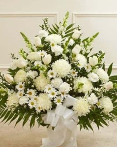 <p>Offer a heartfelt expression of sympathy with the quiet beauty of all-white blooms. This Touching Tribute Floor Basket in white is a graceful and elegant arrangement thoughtfully designed to bring comfort and honor the memory of a loved one with dignity and care.</p>
<p>The serene display features a hand-selected blend of fresh white roses, mums, snapdragons, and complementary seasonal flowers, all carefully arranged in a classic floor basket. The soft, monochromatic palette evokes purity, peace, and reverence—making it a fitting tribute for memorial services, funeral homes, or celebration of life gatherings.</p>
<p>Whether sent by family, friends, or colleagues, this arrangement delivers a respectful message of support and remembrance. The upright design and lush texture allow it to stand beautifully near the casket or memorial display, creating a calming presence during times of mourning.</p>
<p>Each floor basket is handcrafted by skilled florists with attention to detail and care. Reliable same-day delivery is available to funeral homes and service venues, ensuring your thoughtful gesture arrives fresh, full, and professionally presented.</p>
<p>Adding a personal sympathy message at checkout lets you accompany your gift with words of comfort. This elegant basket helps you express what words alone cannot—that you are thinking of them and honoring a life that meant so much.</p>