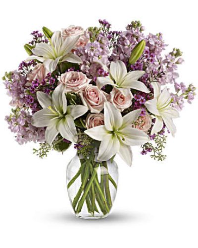 <p>Express love with timeless elegance through a bouquet that speaks straight to the heart. Soft, fragrant, and full of emotion, this arrangement captures the beauty of both new romance and enduring affection. It offers a graceful way to say “I love you,” “I appreciate you,” or “You mean the world to me” when words alone don’t feel like enough.</p>
<p>A gentle mix of light pink spray roses, white Asiatic lilies, lavender stock, and sprigs of lavender waxflower creates a soothing palette of pastel tones. Lush greenery adds contrast and structure, while a clear glass vase completes the look with understated refinement. Each flower contributes its own texture and symbolism, blending into a bouquet that’s charming and meaningful.</p>
<p>This design is a perfect choice for romantic celebrations like anniversaries or Valentine’s Day, as well as spontaneous gestures of love or admiration. Its delicate hues and thoughtful composition make it just as fitting for an intimate dinner as for a heartfelt surprise left on the doorstep.</p>
<p>Every bouquet is handcrafted by a skilled florist and delivered fresh with care. To honor seasonal changes and ensure quality, some flowers may vary slightly in appearance or arrive in bud form. These natural variations enhance the beauty and longevity of the arrangement while keeping the overall design true to its romantic spirit.</p>
<p>Let your affection bloom with a floral gift that reflects tenderness, devotion, and thoughtfulness—a beautiful way to show someone they’re deeply cherished.</p>