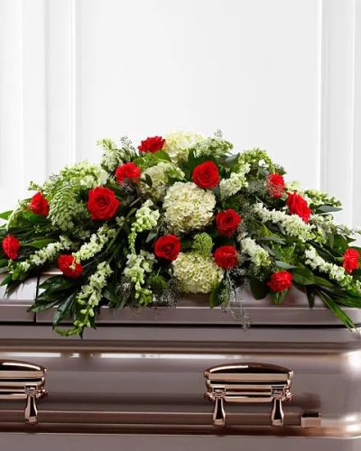 <p>Honor a life well lived with this heartfelt casket spray, a floral tribute that offers comfort, beauty, and quiet strength during times of loss. This refined design is filled with rich, vibrant blooms carefully chosen to convey love, respect, and enduring remembrance. Designed to rest atop the casket, it serves as a touching final farewell that reflects the depth of your emotions and the legacy of the one who has passed.</p>
<p>The arrangement features a striking blend of classic red roses and deep red carnations, symbolizing devotion and affection. These vivid blooms are softened by the delicate presence of white hydrangea, elegant snapdragons, and larkspur, along with airy Queen Anne’s Lace. A thoughtful mix of lush greenery adds natural shape and serenity, helping to create a full and balanced display. Every flower is hand-placed with care to form a graceful cascade across the casket, offering a powerful message of peace and remembrance.</p>
<p>This spray is ideal for memorial services, funerals, and wakes, offering loved ones a way to express sympathy and respect with dignity and grace. The red and white color palette speaks to the beauty of a life filled with love, while the overall design provides comfort to those in mourning. It is a meaningful way to show support and honor someone who made a lasting impact.</p>
<p>Each casket spray is thoughtfully arranged with expert care and professionalism. Same-day delivery is available to funeral homes, churches, and private services to ensure your flowers arrive fresh and on time for the ceremony.</p>
<p>Include a message of sympathy at checkout to accompany this floral tribute. Express love and support with a meaningful arrangement that speaks when words alone are not enough.</p>