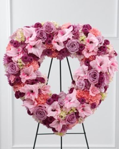 <p>When words cannot fully express your sorrow, offer a heartfelt tribute with this elegant standing heart floral arrangement. Designed to honor a cherished life with warmth and grace, it provides comfort and a meaningful expression of sympathy during times of farewell and remembrance.</p>
<p>This standing heart features a delicate blend of lavender and pink blooms chosen for their symbolism of admiration, love, and grace. Lavender roses convey reverence, while pink carnations represent sweetness and remembrance. Complementing these are lavender chrysanthemums, purple button poms, and pink gladiolus, adding texture and depth, all gently balanced by soft pink hydrangea to create fullness and serenity throughout the design.</p>
<p>Each flower is carefully selected for freshness and significance and expertly arranged to ensure a respectful and touching presentation. Mounted on a sturdy wire easel, this tribute stands tall at memorials or funeral services, serving as a beautiful expression of enduring love and remembrance.</p>
<p>Perfect for honoring mothers, grandmothers, daughters, or anyone whose gentle spirit touched many lives, this arrangement serves as a comforting reminder of the deep affection and lasting memories they leave behind. Its elegant design reflects both grace and heartfelt sentiment.</p>
<p>Delivered with care and compassion, this standing heart arrives ready to provide solace and support to grieving families. It is more than a floral arrangement—it is a meaningful symbol of lasting devotion and a dignified way to say goodbye.</p>