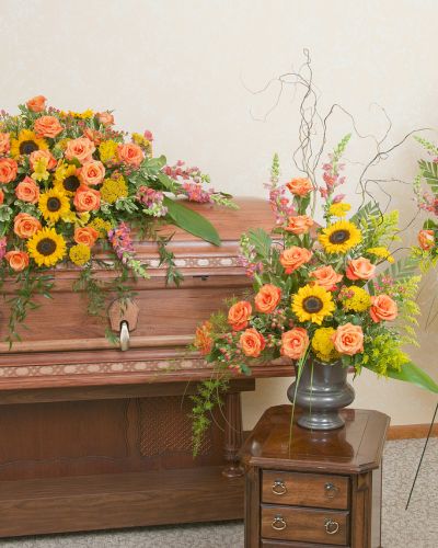 <p>Honor a beautiful life with the warm, peaceful tones of a setting sun. This floral tribute trio offers a heartfelt expression, thoughtfully designed to bring comfort and reflection through soft, radiant colors and graceful composition.</p>
<p>The set includes a coordinating casket spray, standing spray, and urn arrangement, all crafted in rich sunset hues. Featuring fresh blooms in shades of orange, gold, coral, and soft red, each piece is carefully arranged to create a unified and inspiring presence at any funeral or memorial service.</p>
<p>Perfect for close family members wishing to convey deep love and lasting admiration, this trio expresses warmth, gratitude, and eternal peace. The arrangements serve as a moving reminder of a life that brought light to others and left a lasting impression.</p>
<p>Each piece is handcrafted by expert florists who prioritize freshness and thoughtful presentation. The tribute arrives beautifully arranged and ready to offer solace and honor.</p>
<p>Include a personalized message to accompany this radiant tribute. This floral trio allows you to say goodbye with beauty, warmth, and the peaceful grace of a final sunset.</p>
