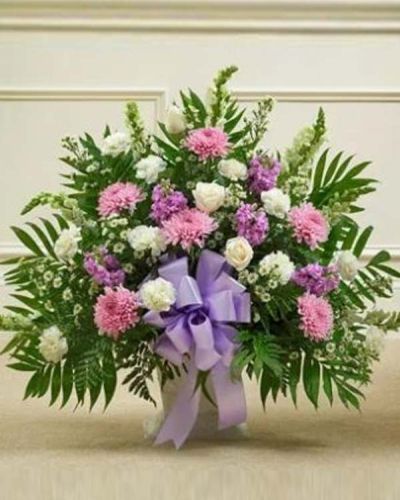 <p>Offer a graceful expression of remembrance with a floral tribute that blends beauty, serenity, and heartfelt support. The Touching Tribute Floor Basket in lavender and white is a tender way to honor a loved one and share your sympathy with those who are grieving.</p>
<p>This elegant arrangement features a soft mix of white roses, snapdragons, and carnations, paired with soothing lavender mums, lavender stock, and additional seasonal accents. Hand-arranged in a traditional floor basket, the design balances purity and peace with gentle color and warmth.</p>
<p>The lavender blooms represent dignity, grace, and a life well lived, while the white flowers symbolize reverence and eternal peace. Suitable for sending directly to funeral homes, this tribute is appropriate for family, friends, or business associates wishing to express condolences in a respectful and meaningful way.</p>
<p>Each Touching Tribute Floor Basket in lavender and white is carefully handcrafted by expert florists with attention to detail. Same-day delivery is available to funeral homes and service venues throughout the local area.</p>
<p>Add a thoughtful message at checkout to accompany your tribute. With its calming colors and elegant design, this basket serves as a comforting reminder of love, support, and remembrance.</p>