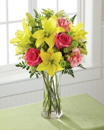<p>Bring color, warmth, and joy into someone’s day with this bright and lovely bouquet. Crafted to surprise and delight, it radiates happiness through every fresh bloom.</p>
<p>Golden yellow Asiatic lilies take center stage, surrounded by a lively mix of hot pink roses, pink carnations, and sunny yellow solidago. Accented with lush greenery and presented in a classic clear glass vase, this bouquet feels like a burst of sunshine—perfect for lifting spirits and celebrating special moments.</p>
<p>Whether sending birthday wishes, expressing thanks, or marking milestones, this bouquet is a perfect gesture. Its energetic color palette and fresh design make it ideal for anyone who appreciates beauty, positivity, and thoughtful surprises.</p>
<p>Handcrafted by expert florists, each bouquet is made fresh and available for same-day delivery locally. Every stem is arranged with care to ensure your gift makes a lasting impression.</p>
<p>Add a heartfelt message during checkout to personalize your delivery. This bouquet is ready to brighten any room and every heart. Order now to send a vibrant reminder of how beautiful each day can be.</p>