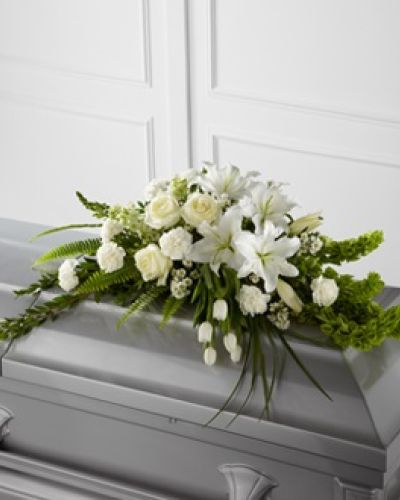 <p>Offer a message of comfort and renewal with this graceful casket spray, designed to inspire serenity and remembrance. Its uplifting blend of white blooms and vibrant green accents reflects the beauty of life, the depth of love, and the hope of everlasting peace.</p>
<p>This elegant arrangement features white tulips, roses, snapdragons, Oriental lilies, larkspur, carnations, and monte casino asters. Bright green Bells of Ireland add height, movement, and a sense of promise, while a variety of premium greenery provides texture and fullness. Carefully arranged, the design flows softly across the casket, offering a peaceful presence during a final farewell.</p>
<p>Ideal for traditional services, memorials, or celebrations of life, this casket spray embodies purity, spiritual renewal, and dignity. Its timeless white and green palette symbolizes peace, reverence, growth, and eternal life.</p>
<p>Each arrangement is handcrafted with care and prepared fresh to order. Delivery is coordinated with local funeral homes to ensure respectful and timely service. Same-day delivery is available throughout the area.</p>
<p>Add a personal message during checkout to accompany your tribute. This casket spray is a meaningful way to honor someone who brought light and grace into the world, offering peace and remembrance in a heartfelt expression.</p>